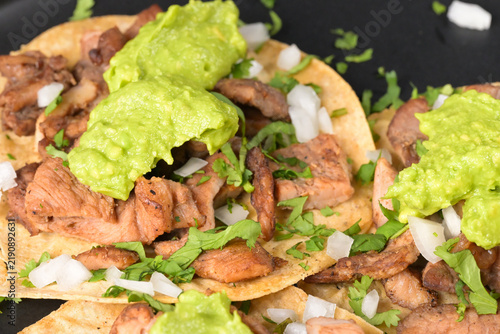 Traditional beef tacos with creamy avocado, cilantro and diced white onion