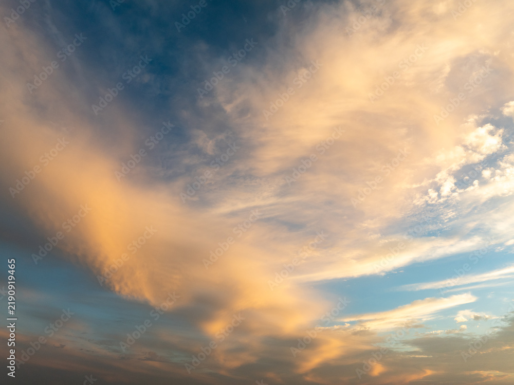 Fototapeta premium Golden clouds in a blue sky with beautiful sunset colors