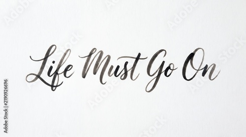 Typography Phrase Life Must Go on Written in Black Ink on White Paper