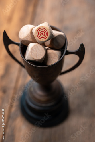 Plakat Wooden Trophy with Dice Featuring Target Symbols on a Rustic Table