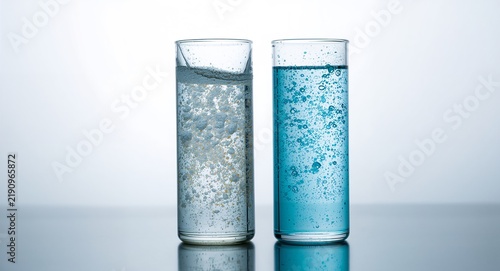 Side by side comparison of clear vs dirty water samples held in glass cylinders highlighting turbidity and color difference for educational context and creative