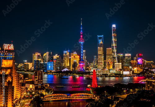 Photography Shanghai CBD's stunning night view, displaying colorful neon lights of the iconic and dense skyscrapers, reflecting China's economic prosperity