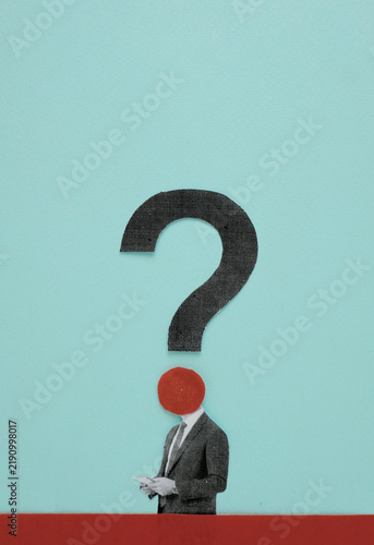 Paper cutout businessman standing under large question mark on blue background
