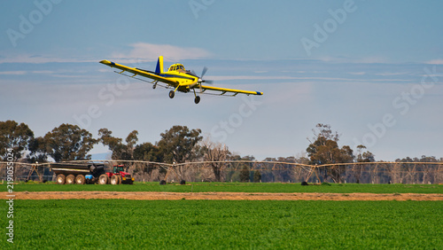Quadro su tela Crop duster flies past tractor on Yarrawonga paddock