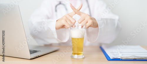Obraz na płótnie Doctor hand stop to refuse Beer, quitting drink for healthy liver, prevent Alcoh
