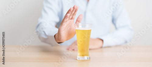 Фотография man making stop hand gesture to refuse a glass of Beer, Healthy man say no to alcohol drink, stop alcoholism and addiction concept
