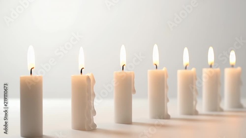 Row Of Lit White Candles With Melting Wax And Soft Lighting