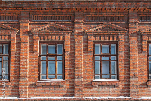Two windows of the old mansion 19 century with brown bricks wall