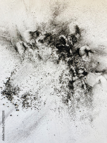 White art paper with patterns of black charcoal smudges, dust and granules on the paper surface