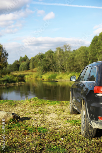 Фотография Off-Road Adventure: SUV by Serene Lake in Scenic Natural Landscape