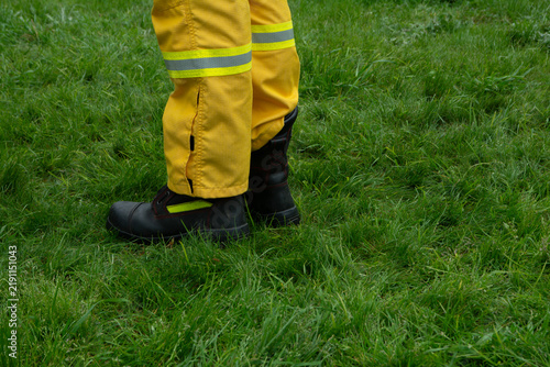 legs and boots of firefighters wearing yellow protective uniforms