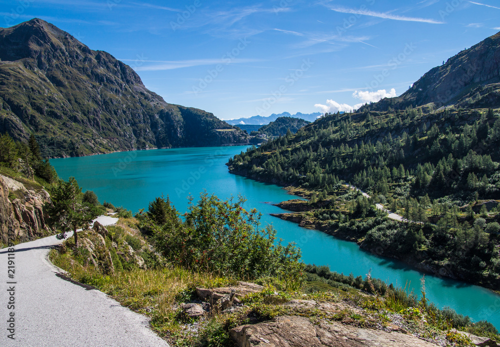 Fototapeta premium Bright turquoise alpine lake and winding mountain road