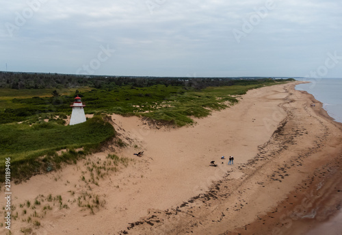 Foto Aerial view of a lighthouse on a sandy beach coastline of PEI