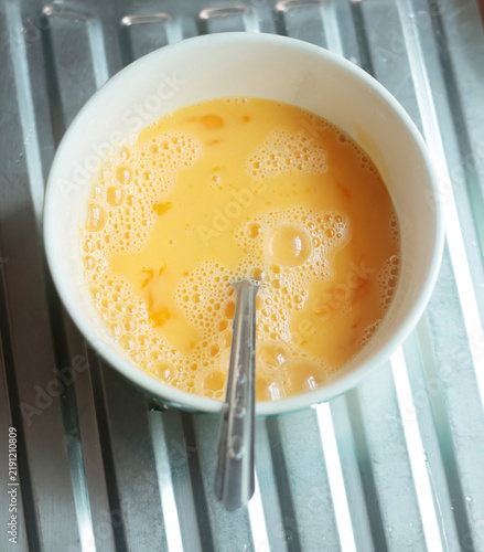 Cracking a raw egg into a bowl, preparing to fry an egg.