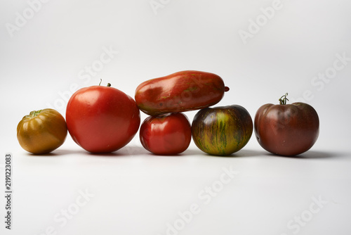 Assorted heirloom tomatoes of different colors and varieties on white background