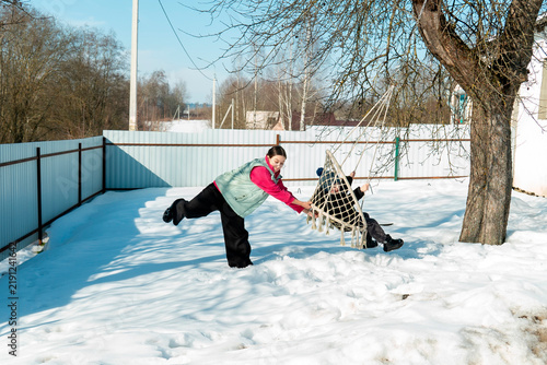 Children enjoy playing and swinging in the snow on a winter day in a backyard setting