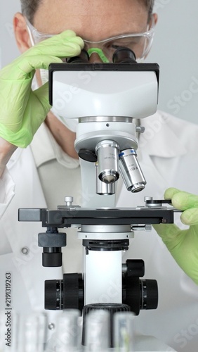 Canvastavla Scientist in personal protective equipment working with a professional microscop