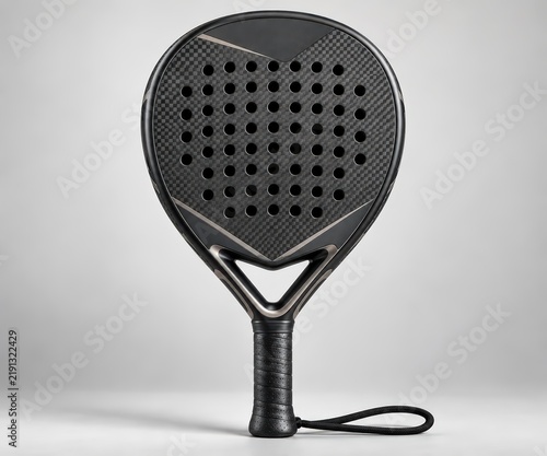 Modern black padel racket with sophisticated carbon fiber detailing and perforated face, presented vertically on a clean gray surface, perfect for sports equipment branding.