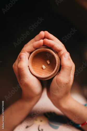Принти на полотні Description: Close-up of child’s hands holding a small wooden keepsake box with baby teeth inside, symbolizing a childhood milestone
