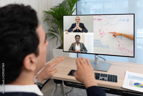 Back view of businessman in black suit  videoconference on-line meeting with the investment advisor. Work from home concept