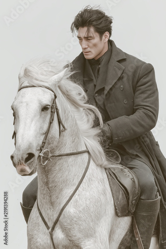Man in Victorian attire on a white horse