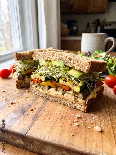 Healthy grilled vegetable and hummus sandwich on wooden board