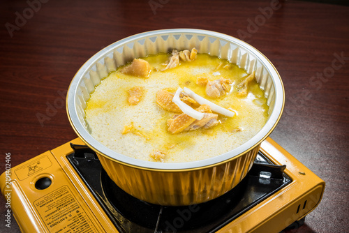 Фотография Milky chicken broth simmering on stove