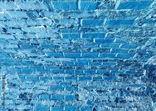 Canvastavla An abstract, stylized close-up texture background of an ancient masonry wall inverted in cool blue tones, showcasing a unique patterned surface with weathered brick shapes and rough mortar details