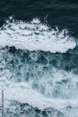 фотографія Natural background of blue ocean waves with white sea foam and turquoise water,