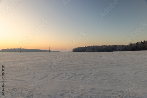a beautiful sunset or sunrise on a snow-covered field in winter, hoar frost