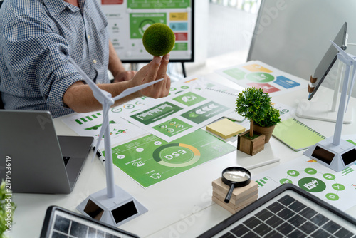 Business Team Analyzing Green ESG Sustainability Reports with Renewable Energy Models in Modern Office