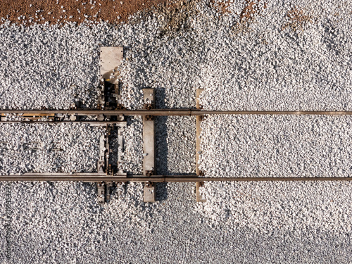 Aerial view of railway tracks with gravel ballast and a track switching mechanism in Gdansk, Poland.