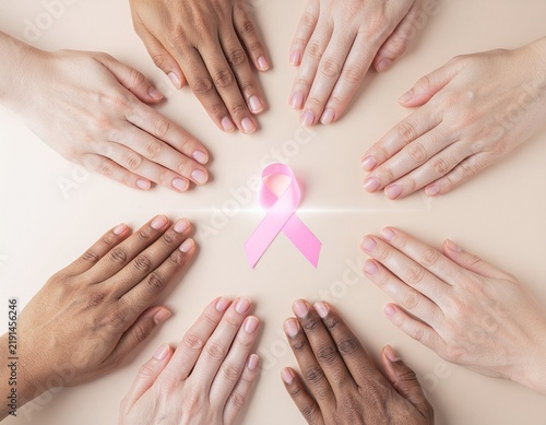 Diverse Hands Surrounding Pink Ribbon in Support of Breast Cancer Awareness
