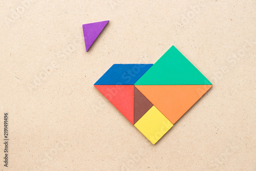 Фотография Color tangram puzzle wait for fulfill to heart shape on wood table