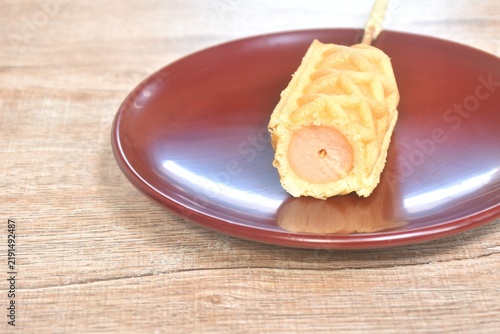 baked butter waffle corn dog stuffed pork sausage stabbing wooden stick on plate