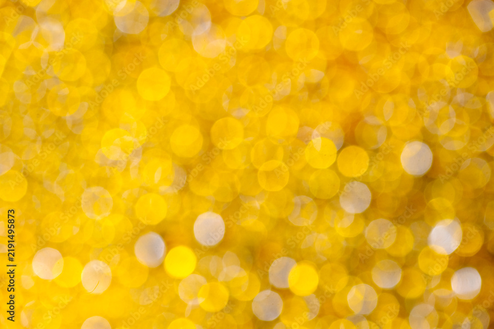 Obraz premium Abstract golden yellow bokeh background with sparkling, out-of-focus festive lights. Abstract holiday illumination and decoration background