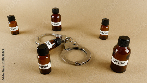 Cuadro en lienzo Handcuffs and vaccine bottles symbolizing medical control and mandates
