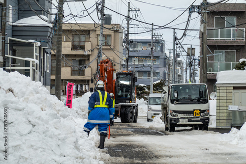 Obraz w ramie 冬の住宅街で交通確保のために行われる除雪作業と道路の雪山 ,北海道 札幌市