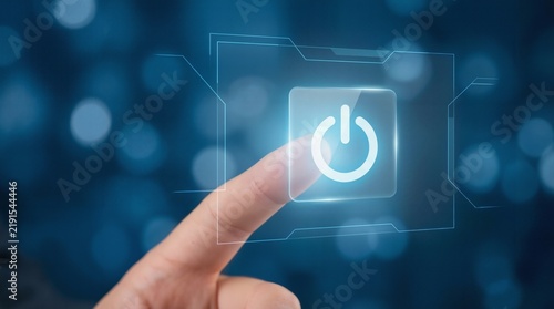 Human finger touching glowing digital power button icon on transparent virtual futuristic interface screen