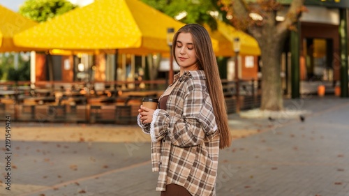 Quadro su tela Young woman enjoying a coffee break outdoors on a crisp autumn day