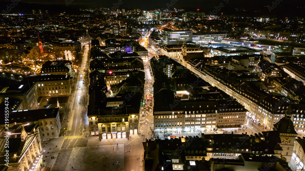 Fototapeta premium Drone aerial night panorama over Bundesplatz and illuminated Old Town streets in Bern, Switzerland