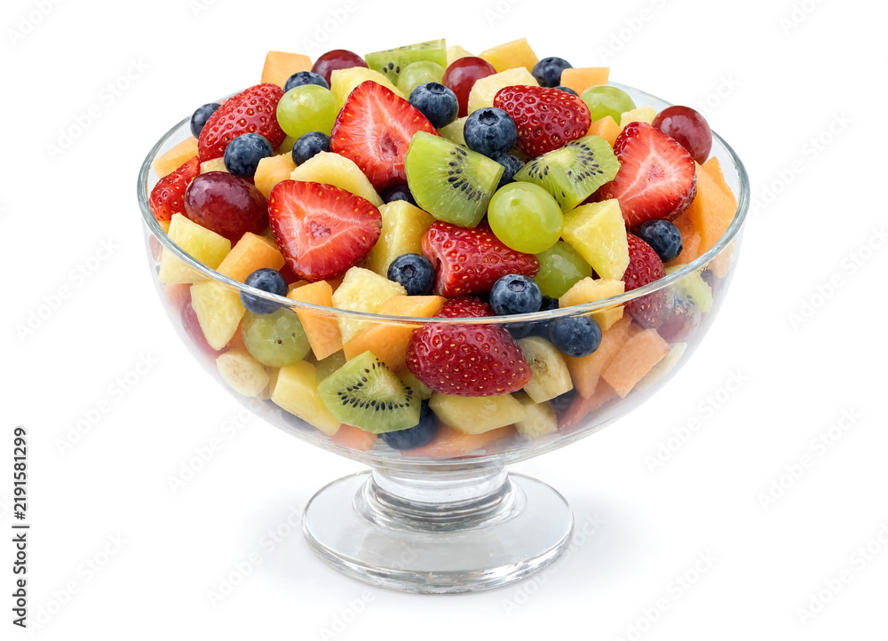 Obraz premium Fruit salad in a deep dessert bowl, isolated on a white background.