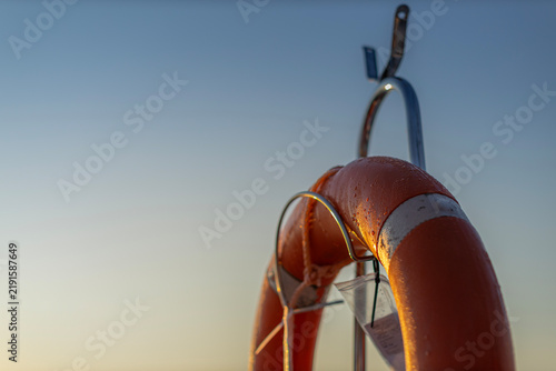 Orange Marine Life Ring on Sailing Boat at Sunrise with Sky Copy Space