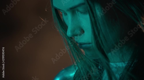 Caucasian young woman wearing chainmail armor standing with eyes closed during camera tilt up. Suitable for fantasy film trailers, historical storytelling, or gaming commercials