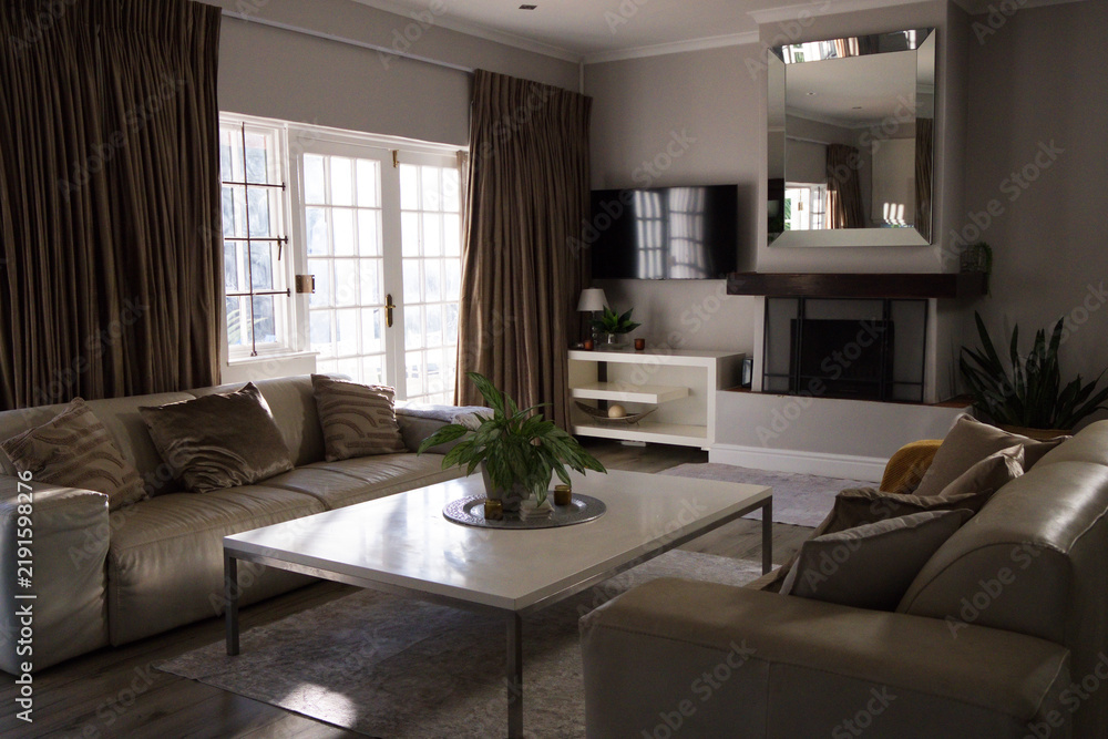 Obraz premium White coffee table is sitting between sofas in living room, holding tray with plant and candles