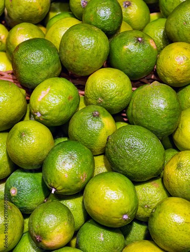 Obraz na plátne Yellow green limes displayed for sale on a supermarket counter, presenting fresh