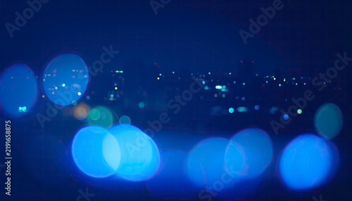 Night Cityscape Bokeh: A dreamy, out-of-focus view of a city at night, with glowing blue and white bokeh lights creating a magical, abstract atmosphere.