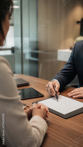 Advisor consulting client over blank forms in private meeting room