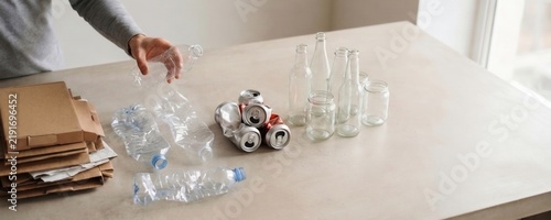 Hand sorting household recyclables by material on table