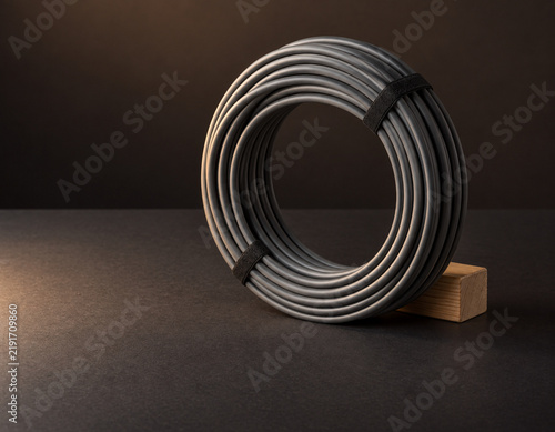 Coiled fiber cable beside a dark uncluttered surface